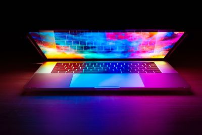 A laptop emitting colorful light from the screen